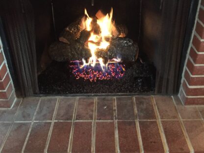 Hargrove radiant heat Cross Timber gas logs inside wood burning fireplace.