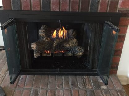 Recently installed natural gas log set into wood burning fireplace.
